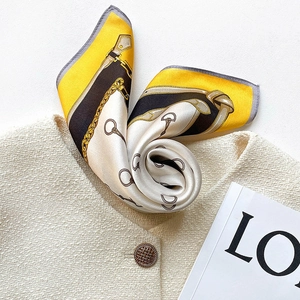 Luxurious silk square scarf featuring equestrian chain prints on a beige tweed jacket