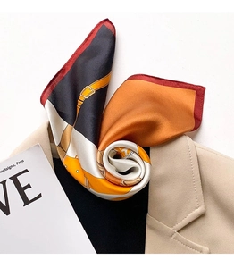Detailed view of luxury silk scarf featuring classic chain prints and elegant hand-rolled edges