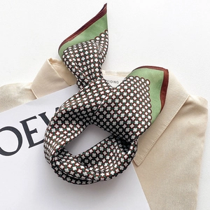 Foulard en soie avec motif de chaîne géométrique verte sur une chemise beige