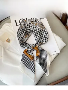 Close-up of silk scarf with houndstooth and paisley patterns on a white suit