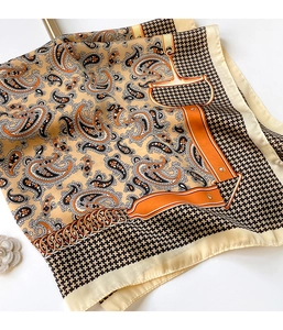 Detail of silk scarf featuring paisley print, houndstooth border and horsebit pattern