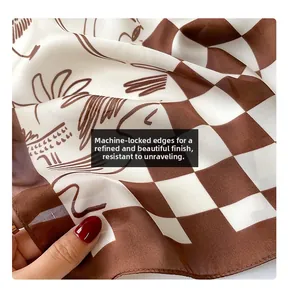 Detailed view of checkered silk scarf with line art portrait and machine-stitched edges