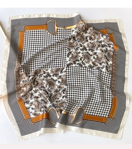 Detail of silk satin scarf featuring classic houndstooth and paisley prints with gold chain patterns