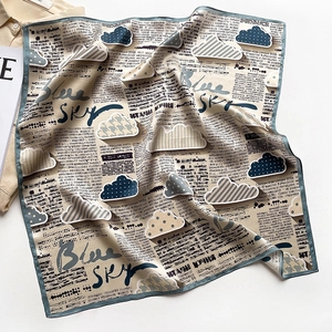 Vue détaillée du foulard en soie avec imprimé journal et motifs de nuages texturés