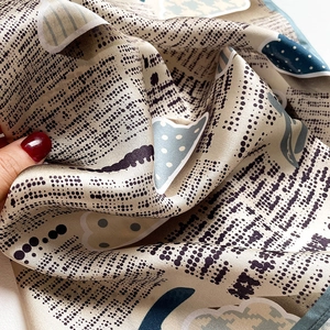 Vue macro détaillée de l'imprimé journal vintage sur un foulard en soie à pois élégants