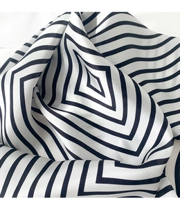 Detailed close-up of striped mulberry silk scarf showing smooth texture and geometric pattern