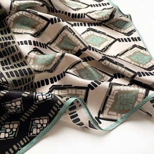 Vue détaillée du foulard en soie satinée à imprimé géométrique vintage avec bords roulés