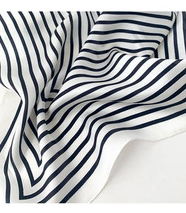 Close-up of black and white striped silk scarf showing soft texture and rolled edges