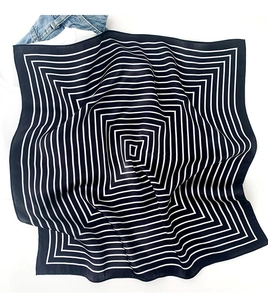 Close-up of a striped silk scarf with monochrome geometric lines on a white background