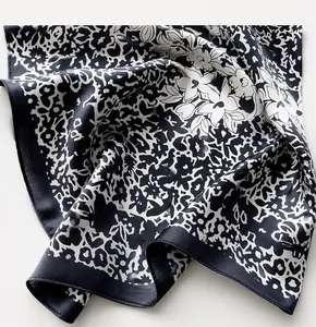 Dettaglio macro di foulard in seta con stampa floreale che mostra trama e cuciture bordi