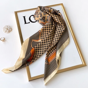 Elegant houndstooth and paisley faux silk scarf displayed with luxury accessories