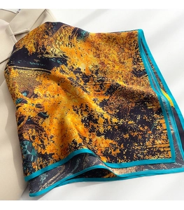 Dettaglio di sciarpa di seta floreale su un blazer con bordi blu e stampe autunnali