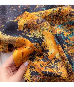 Dettaglio ravvicinato della seta con motivi floreali vivaci in arancio e blu