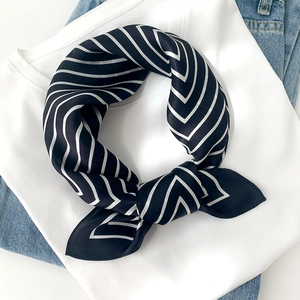 Classic black and white striped silk scarf styled on a white t-shirt and jeans