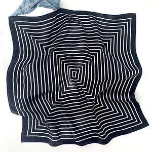 Minimalist black and white striped silk scarf with geometric pattern on a white backdrop