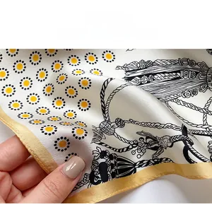 Close-up of silk square scarf featuring detailed fine-stitched edges and floral patterns