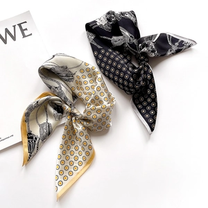 Detailed view of silk neck scarves with daisy and tassel patterns on a minimalist background
