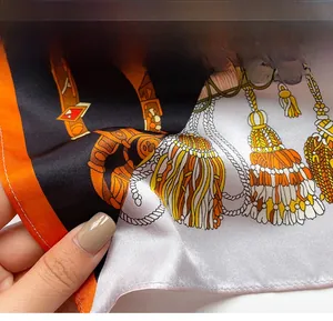 Gros plan d'un foulard en soie montrant des motifs équestres et des ourlets raffinés