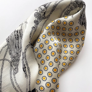 Detail of vintage silk scarf showing wave-like folds, polka dots, and rope print textures