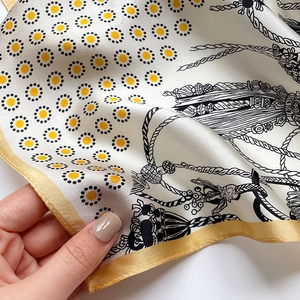 Detailed close-up of premium silk scarf texture with classic equestrian rope patterns