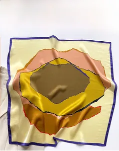 Detail of silk square scarf showing abstract color-block prints and smooth satin texture