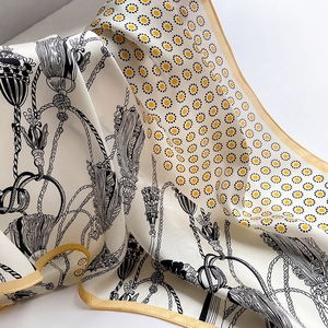 Macro detail of silk scarf showing vintage tassel pattern and gold stitched edges