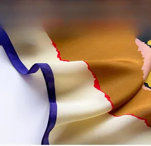 Detail of premium silk scarf featuring delicate purple hemmed edges and tricolor patterns