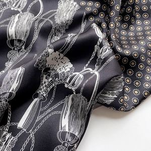 Detailed view of luxury silk scarf with gold polka dots and silver fringe patterns