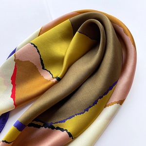 Detailed view of silk square scarf featuring abstract color block pattern and smooth texture