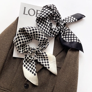 Élégant foulard en soie à pois noir et blanc sur un blazer avec des magazines d'art