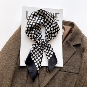 Carré de soie élégant à pois noué en ruban sur un blazer en laine chic