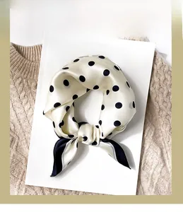 Detailed view of polka dot silk scarf draped on a magazine for a retro fashion look