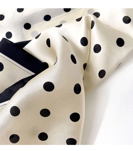 Close-up of smooth silk scarf with classic polka dots and elegant satin finish
