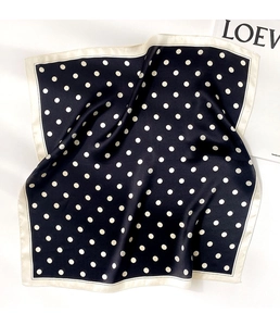 Detail of silk square scarf with classic black and white polka dot pattern and satin finish