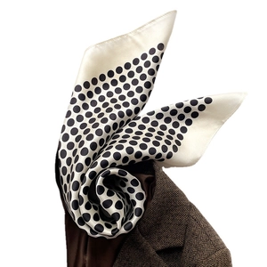 Élégant foulard en soie à pois drapé sur un blazer marron à chevrons pour un look chic