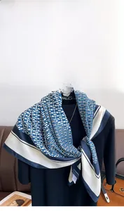 Detail of blue and white twill silk scarf with chain pattern and floral neck accent