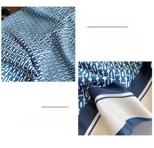 Detail of silk scarf with blue chain letter print and premium stitched edge craftsmanship