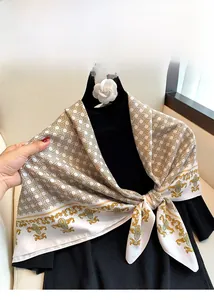 Detail of silk-feel scarf with geometric patterns and baroque gold prints on a black sweater