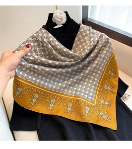 Detail of silk-textured square scarf featuring vintage golden floral patterns and mustard borders