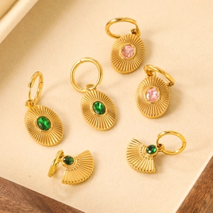 Golden geometric hoop earrings set with emerald green stones and fan shaped textures