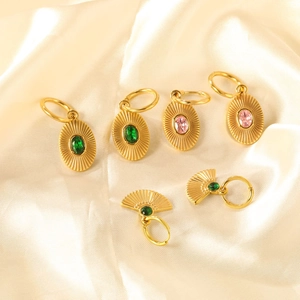 Vintage geometric gold-plated earrings with radiant texture and colored gemstones on satin