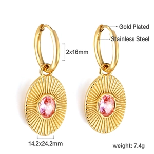 Macro shot of gold plated earrings featuring radial texture and pink zircon stone