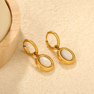 Classic gold stainless steel hoop earrings with oval shell inlay on beige background