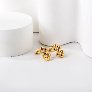 Polished gold multi-ball cluster stud earrings on minimalist geometric background