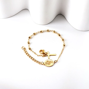 Bracelet perlé doré avec croix et médailles religieuses sur fond blanc minimaliste