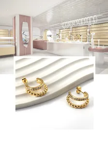 Detail of gold double-layer C-shaped earrings with sparkling pavé cubic zirconia and beads