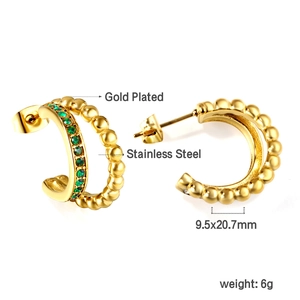 Detail view of gold-plated C-shape earrings with green zircon and steel beads decoration