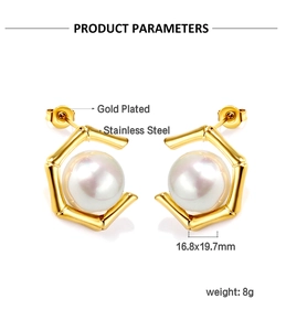 Détail de boucles d'oreilles hexagonales dorées avec perle blanche et texture bambou