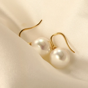 Boucles d'oreilles perles baroques avec crochet doré sur fond satiné luxueux