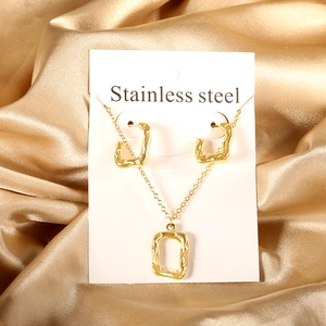 Detail of gold stainless steel necklace and hoop earrings with organic melted texture